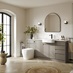 A sand grey, integrated handle bathroom in a single wall layout. The are also white counters and herringbone flooring.