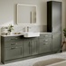 A single-wall, shaker bathroom in a dark, ash green tone. It has sleek, white worktops, a mixer tap, and a ceramic sink.