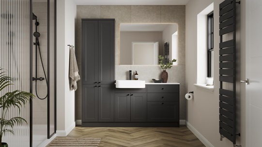 A single-wall, shaker bathroom in a charcoal tone. It has herringbone flooring, white worktops, and a ceramic sink.