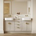 A single-wall, shaker bathroom in a sandstone tone. It has gold taps and handles, dual ceramic sinks, and timber flooring.
