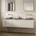 A cream, porcelain-toned bathroom with floating gloss vanity units. The walls have stone-effect panelling and two mirrors.