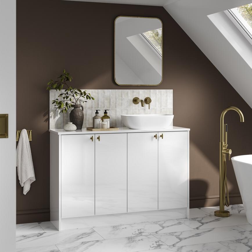 A small white bathroom with gloss cabinets and brass fittings. There is marble wall panelling and matching floors throughout