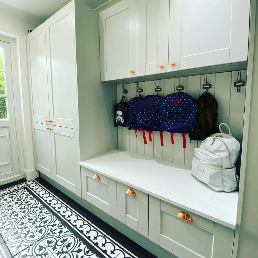 Boot room storage idea using different depths of cabinets to create a spacious seating area.