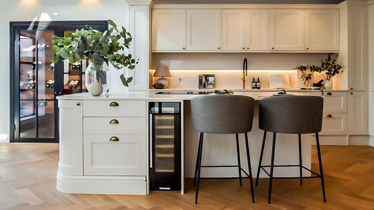 Elmbridge porcelain kitchen with a central kitchen island and Lamona wine cooler integrated to the cabinetry.