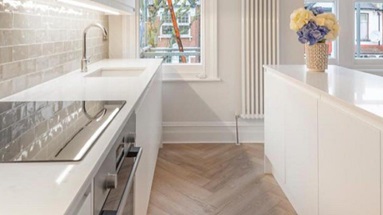 Clerkenwell super matt white kitchen featuring a kitchen island with white quartz worktops.
