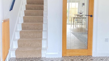 Hallway with a Howdens glazed door with an oak-effect frame, from the Genoa range. The door has black hardware.