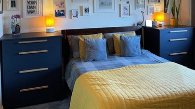 A modern bedroom in navy blue, from @millsy_hv. It has two large bedside table drawer units with brass bar handles.