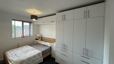 A Hockley Super Matt Dove Grey bedroom from @whitemanclarklimited2023, with chrome t-bar handles and wall cabinets.