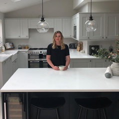 lady in black shirt standing behind navy kitchen island