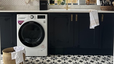 Bold utility room idea using navy shaker units. Includes white worktops, white sink, brass tap and brushed-brass handles.