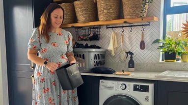 Mel Boyden in her navy utility room. Includes classic shaker units, white worktops, brass handles, and oak open shelving.