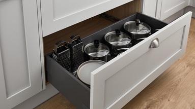 A pull out drawer with a deep capacity, containing pots, pans, and cooking utensils