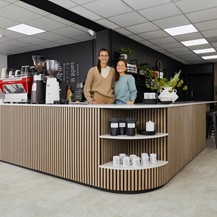Jill Scott Cafe Kitchen Makeover with Jill and her fiancee standing behind a counter with oak wall panelling