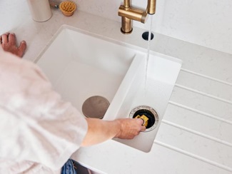 Emma using her Insinkerator waste disposal unit