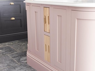 Timber accessories inside a pink, in-frame kitchen