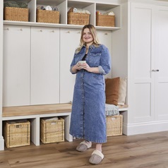 Courtney stood holding a mug, in front of some built in storage units from Howdens