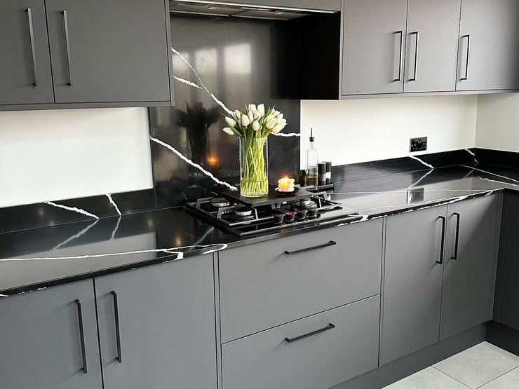 Bespoke worktop idea featuring black marble worktops with a matching upstand and splashback.