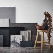 Sensory delight flat lay showing different square and rectangular slabs of textured stone, marble, and black materials.