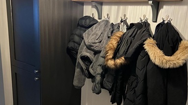 Small boot room ideas with a black, tower unit and a bench made from drawer units.