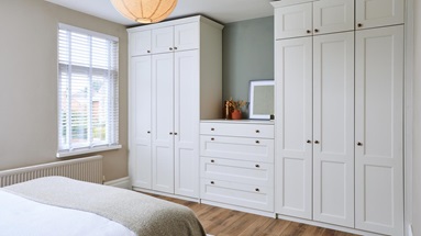 White shaker bedroom with porcelain fronts from the Bridgemere range. There are two tall wardrobe units and matching drawers
