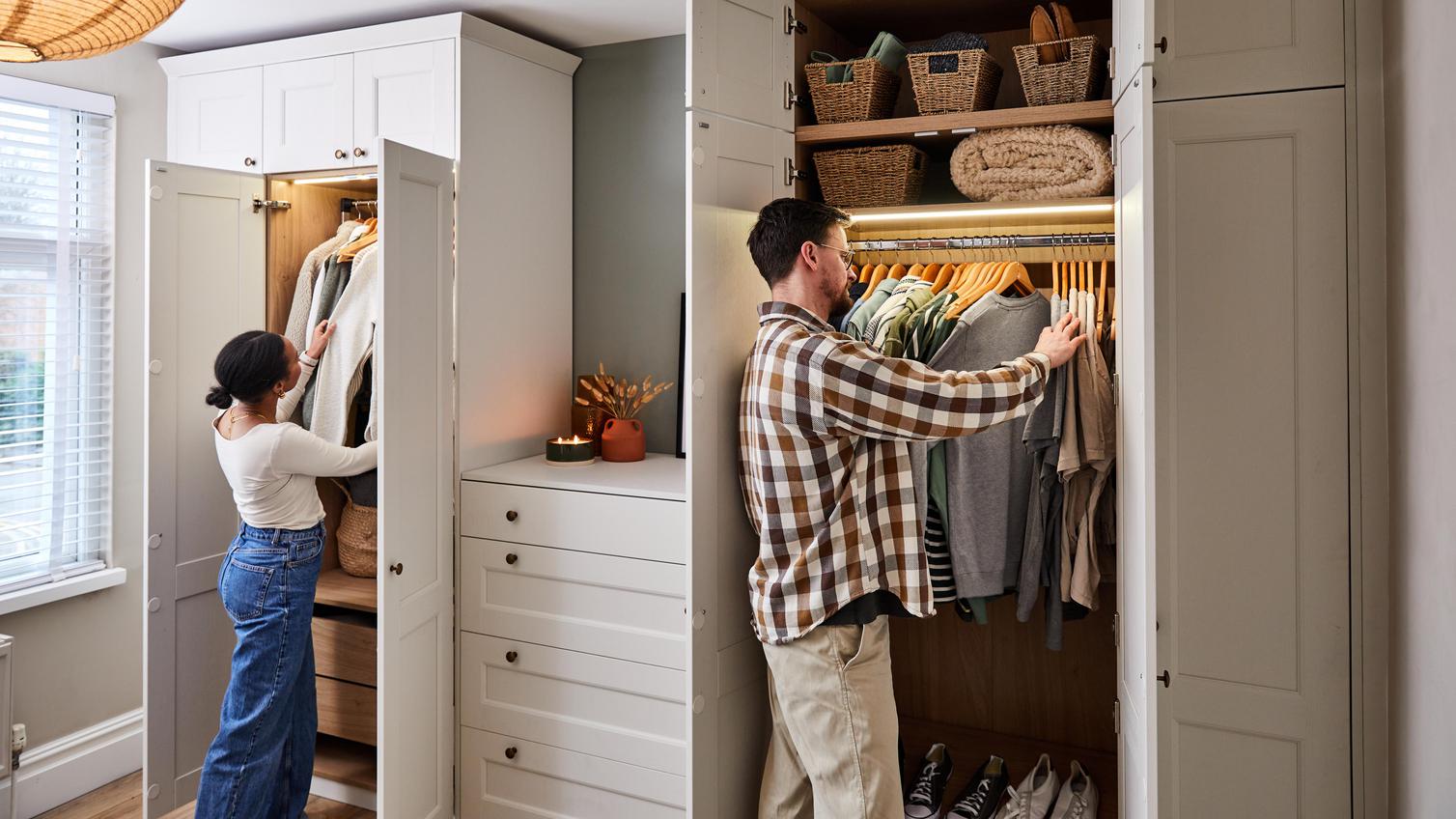 Jade and James going through clothes in the porcelain white wardrobes, with multiple shelves. LED strips light up the inside.