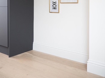 White skirting in a black handleless kitchen