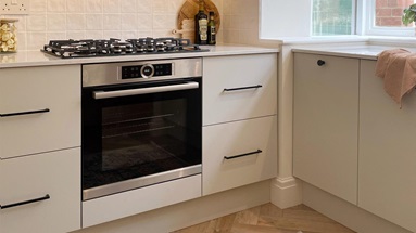 Two-tone kitchen with oak wall cupboards and cream floor units