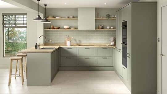 A modern shaker kitchen from the Frome collection in a reed green tone. It has white, tile flooring and a u-shaped layout.