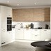 A porcelain kitchen from the Winterton collection. It has a gloss finish, an l-shaped layout, and natural oak wall cabinetry.