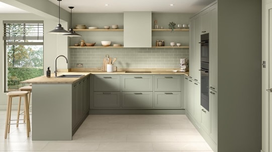 A modern shaker kitchen from the Frome in frame collection. It has a reed green tone, timber worktops, and u-shaped layout.