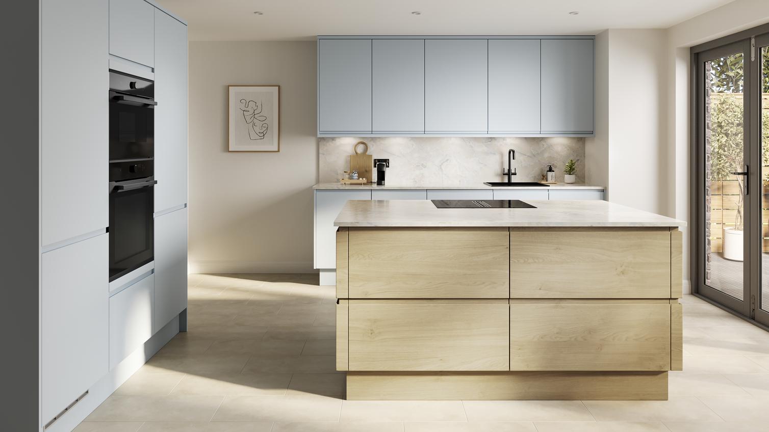 A pale, mist-blue kitchen with integrated handles. It has a kitchen island with oak-effect doors, and stone tile flooring.