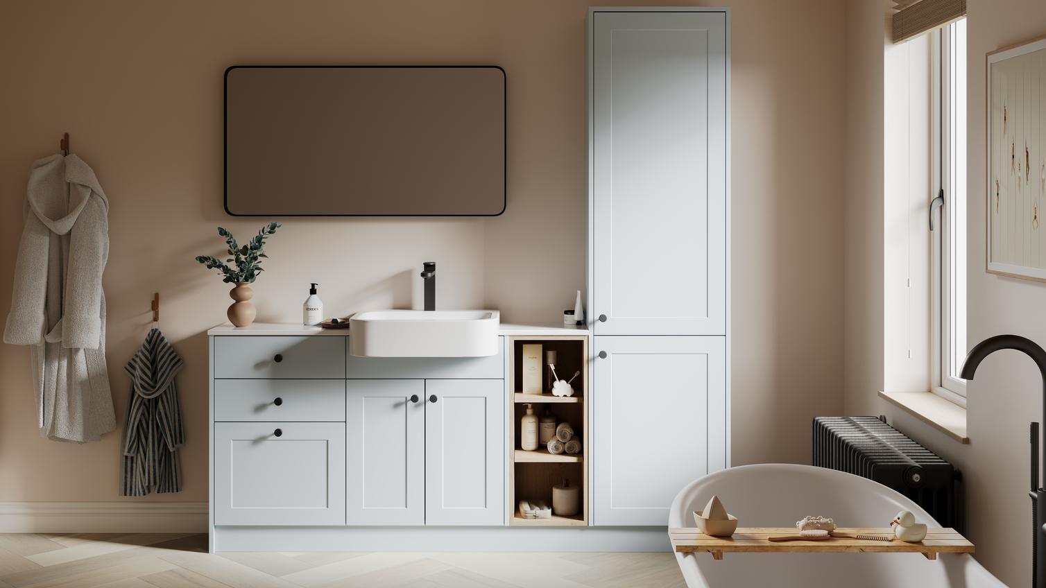 A mist-blue bathroom with shaker vanity unit & matching tall storage cabinet. It has white fittings with black accessories. 