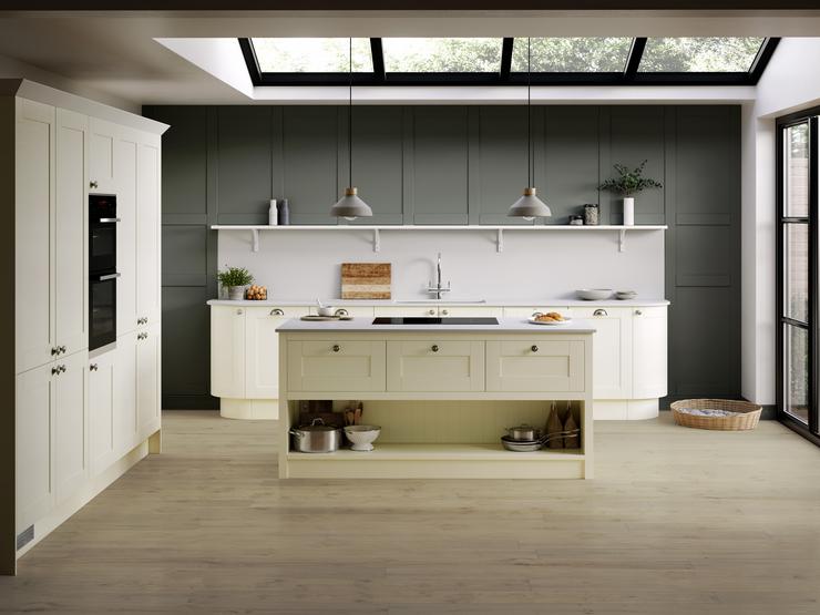 Heritage cream kitchen idea with shaker doors and chrome knob handles in an island layout. Includes green wall panelling.