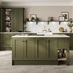 An olive green kitchen in an island layout with white worktops throughout, matching backboard and integrated hob.