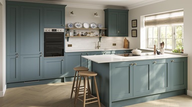 Blue kitchen idea featuring shaker doors in a peninsula layout. Has white worktops and timber floors for a seaside theme.