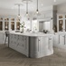 A stately kitchen featuring light-grey shaker doors with a beaded detail and glass dresser cabinets in an island layout.