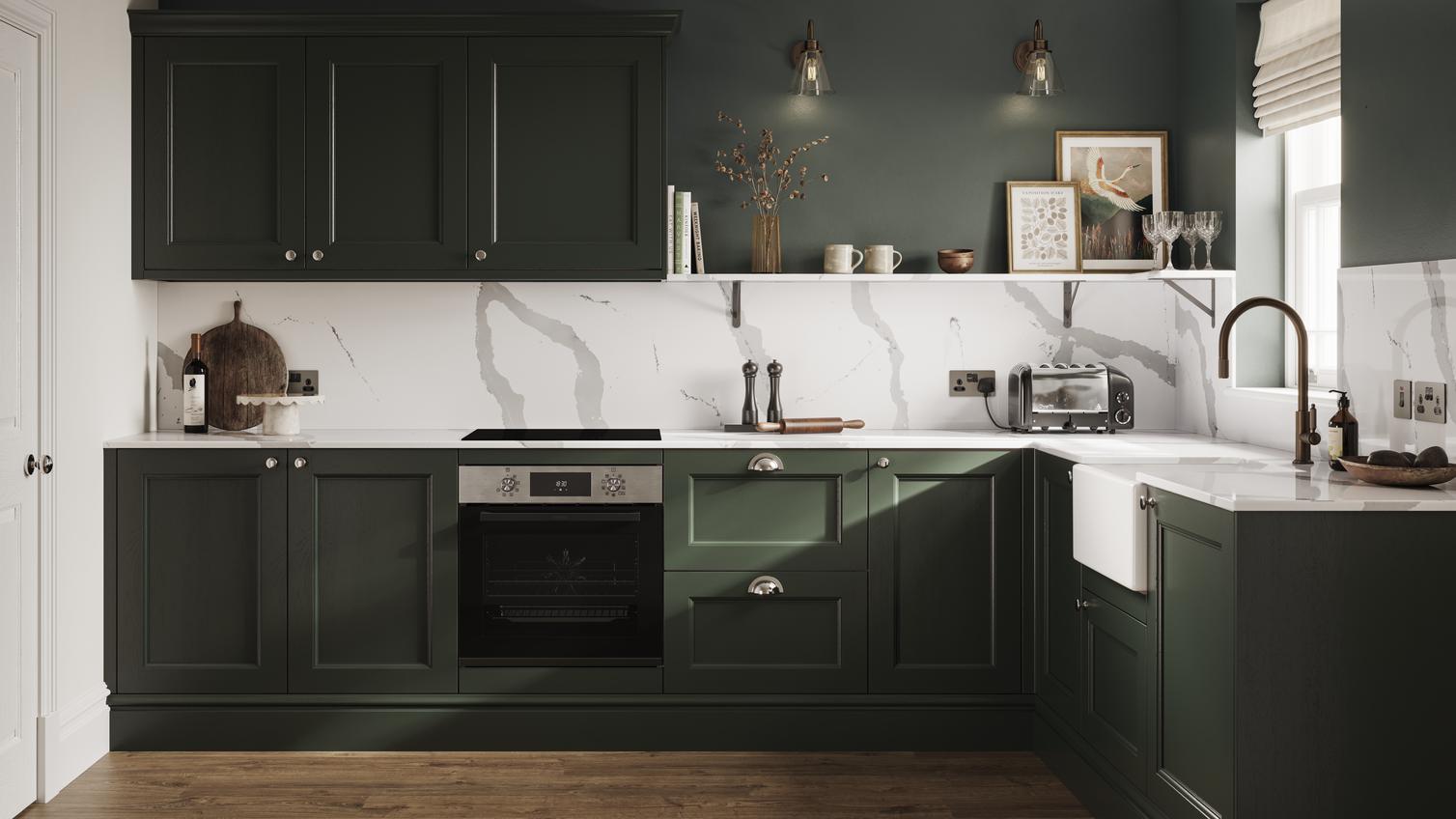 A dark, fir green shaker kitchen in an L-shaped layout. It has white worktops, marble-style backboards, and oak flooring.