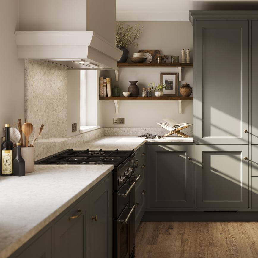 A green kitchen with in-frame, shaker doors in an island layout. It has beige worktops, dark timber shelving, and plank flooring.