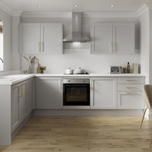 A grey shaker kitchen design with luxury features including a white worktop and backboard, white sink, and brass handles.