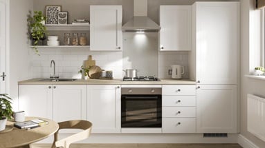 A white shaker kitchen design with classic features including an oak worktop and flooring, chrome handles and a chrome sink.