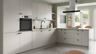 A sandstone kitchen design with matt slab doors, matt black knob handles and tap, and a stone-effect worktop and backboard