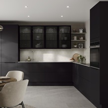 L-shape black kitchen idea with super-matt slab doors, glass wall cabinets above a white worktop, and a chrome kitchen tap.