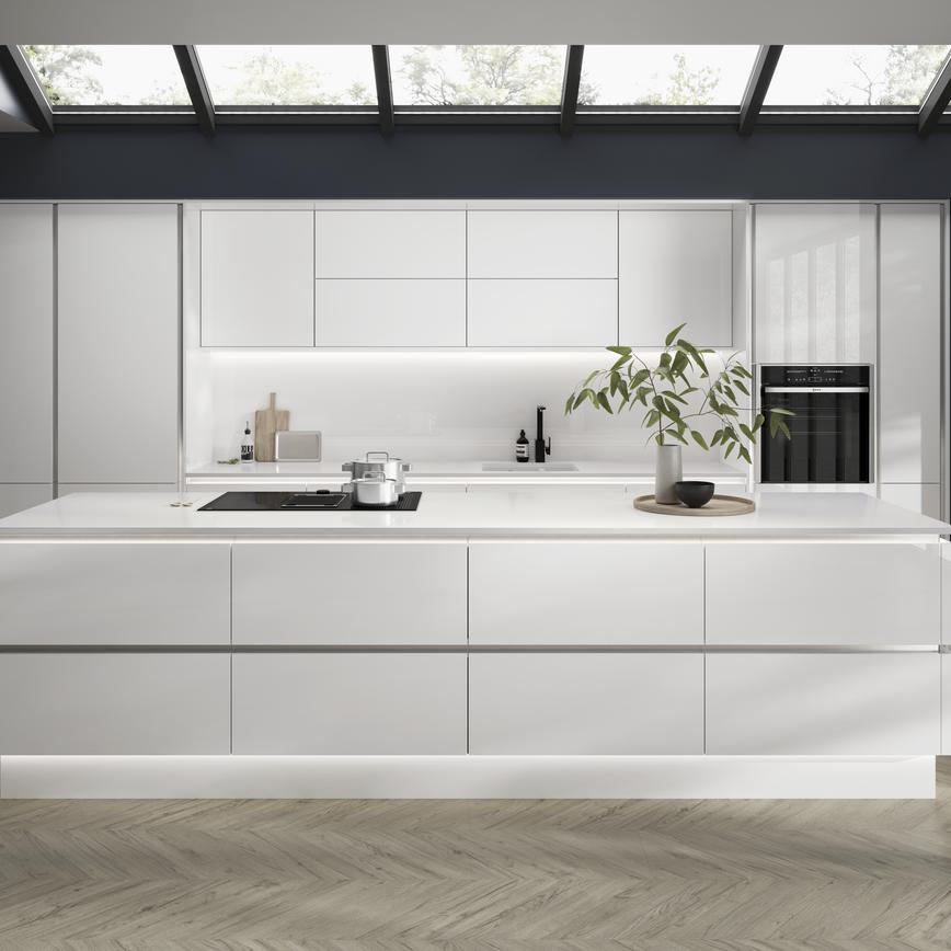 Open-plan white gloss kitchen idea with a linear design. Has white worktops and silver decorative trims for a modern feel.