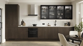 A handleless kitchen in a dark oak finish and single wall layout. There is oak flooring and a marble-effect splashback.