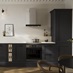 An Ilfracombe black shaker kitchen in a single-wall layout. It has black accessories and a marble-style worktop with upstand