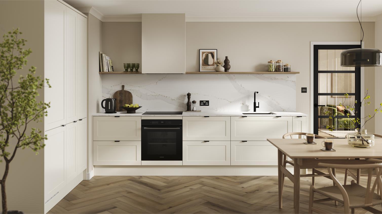 An l-shaped kitchen from Frome Porcelain, with shaker fronts in a matt finish. It has oak flooring & marble-effect worktops. 