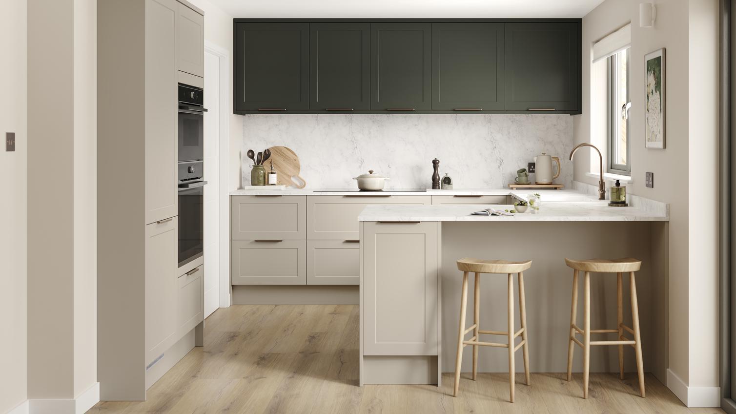 A shaker, sandstone kitchen in a peninsula layout from the Frome range. It has oak plank flooring and green wall cabinets. 