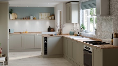 Country cottage style pebble grey shaker kitchen with wood worktop, wall panelling and light grey floral wallpaper.