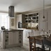 Traditional cream kitchen idea with shaker doors, double ceramic kitchen sink, glass pendant lighting with a kitchen island.
