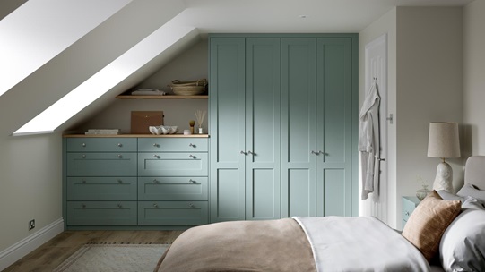 A Halesworth bedroom with seafoam blue wardrobes & drawers. It also has wood-effect flooring, and oak counters & shelving.